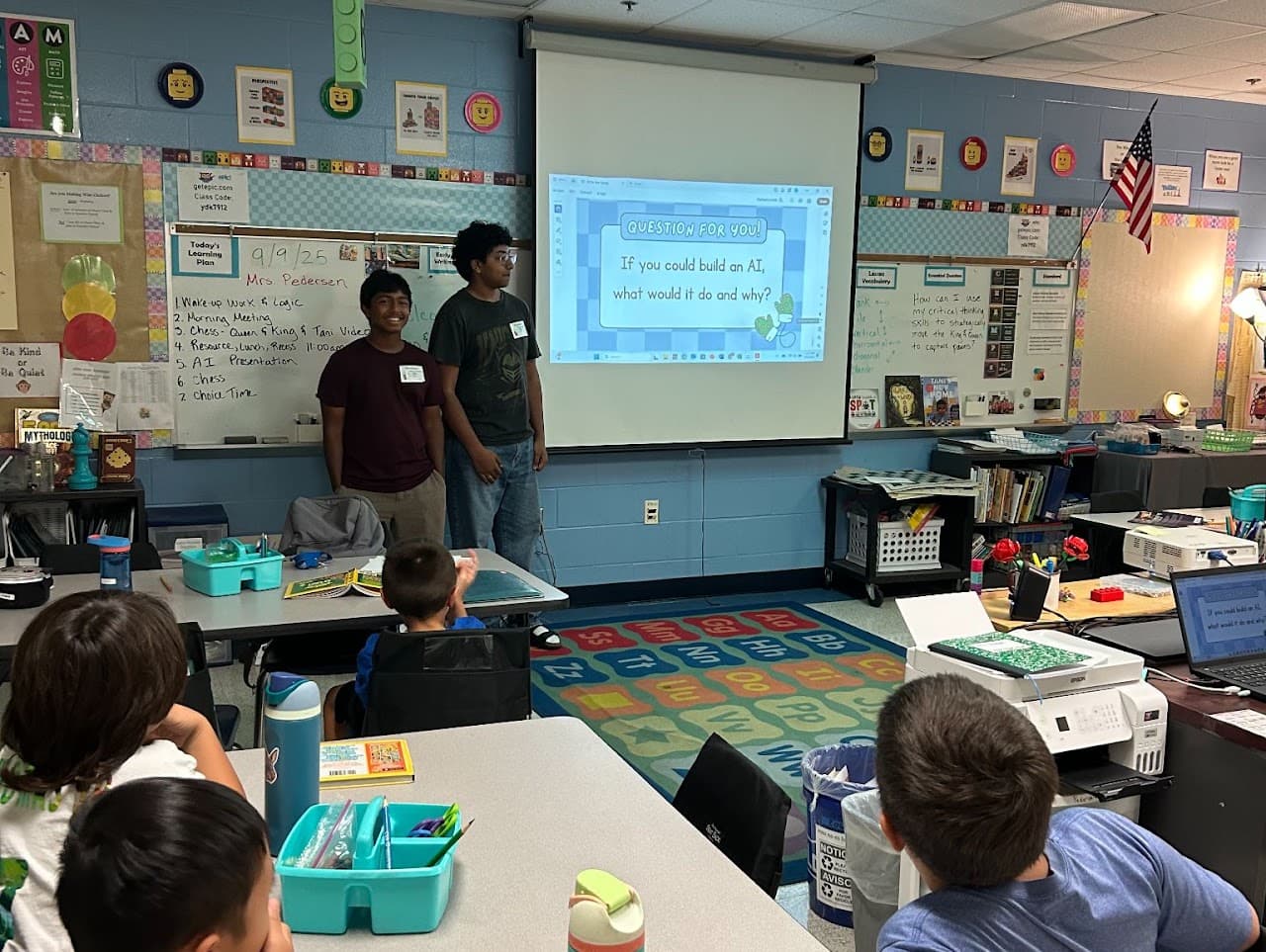 Two AIforALL volunteers leading a classroom discussion about building AI