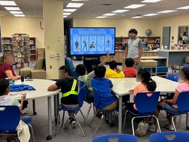 Students learning about AI through movie examples during a library session